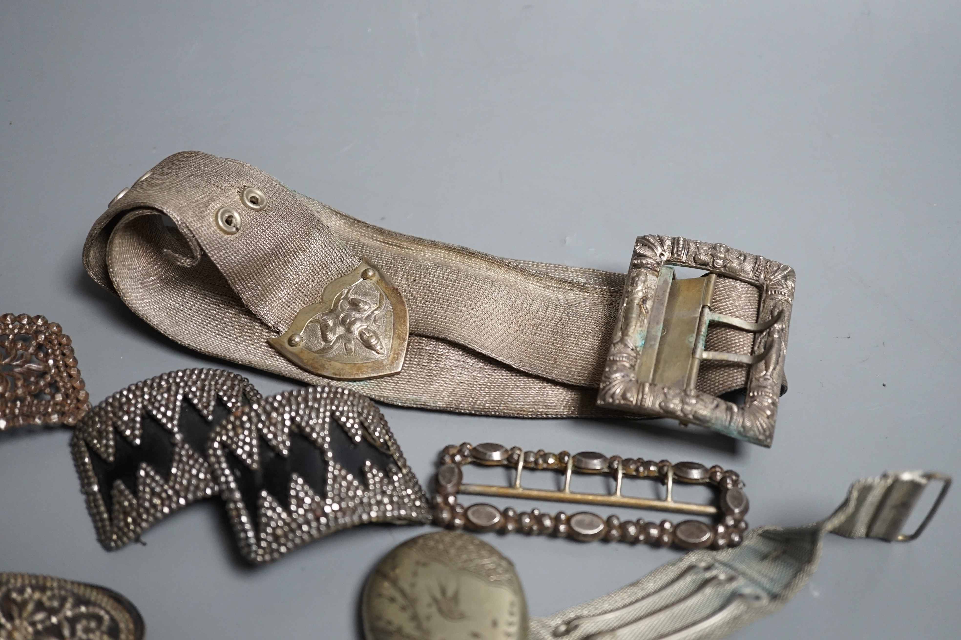 An Indian metal belt, four assorted metal shoe buckles and an aesthetic engraved silver plated vesta case.